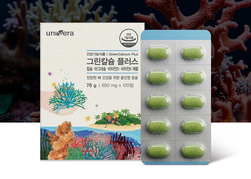 남색 산호 배경 앞 그린칼슘 플러스 상자와 초록 정제 블리스터