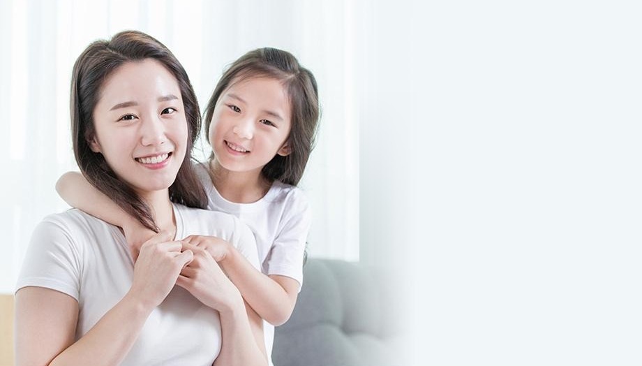 흰 옷을 입은 엄마와 뒤에서 안은 딸이 웃는 모습