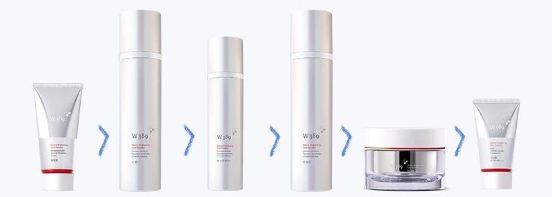 W389 제품 여섯이 차례로 놓인 줄 — 필링젤 튜브, 토너 병, 스팟 에센스 병, 로션 병, 크림 단지, 선크림 튜브(은빛 · 빨간 띠). 사이사이 청보라 꺾쇠